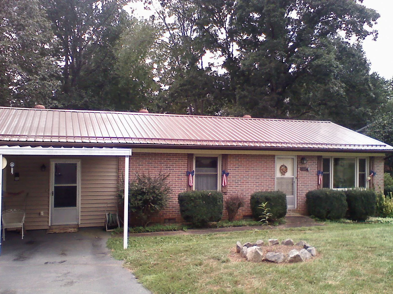 Bronze metal roof and carport on a brick ranch home — Roof Repair work by our crew in Grantville